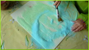 Dessiner avec du sel coloré sur de la colle.